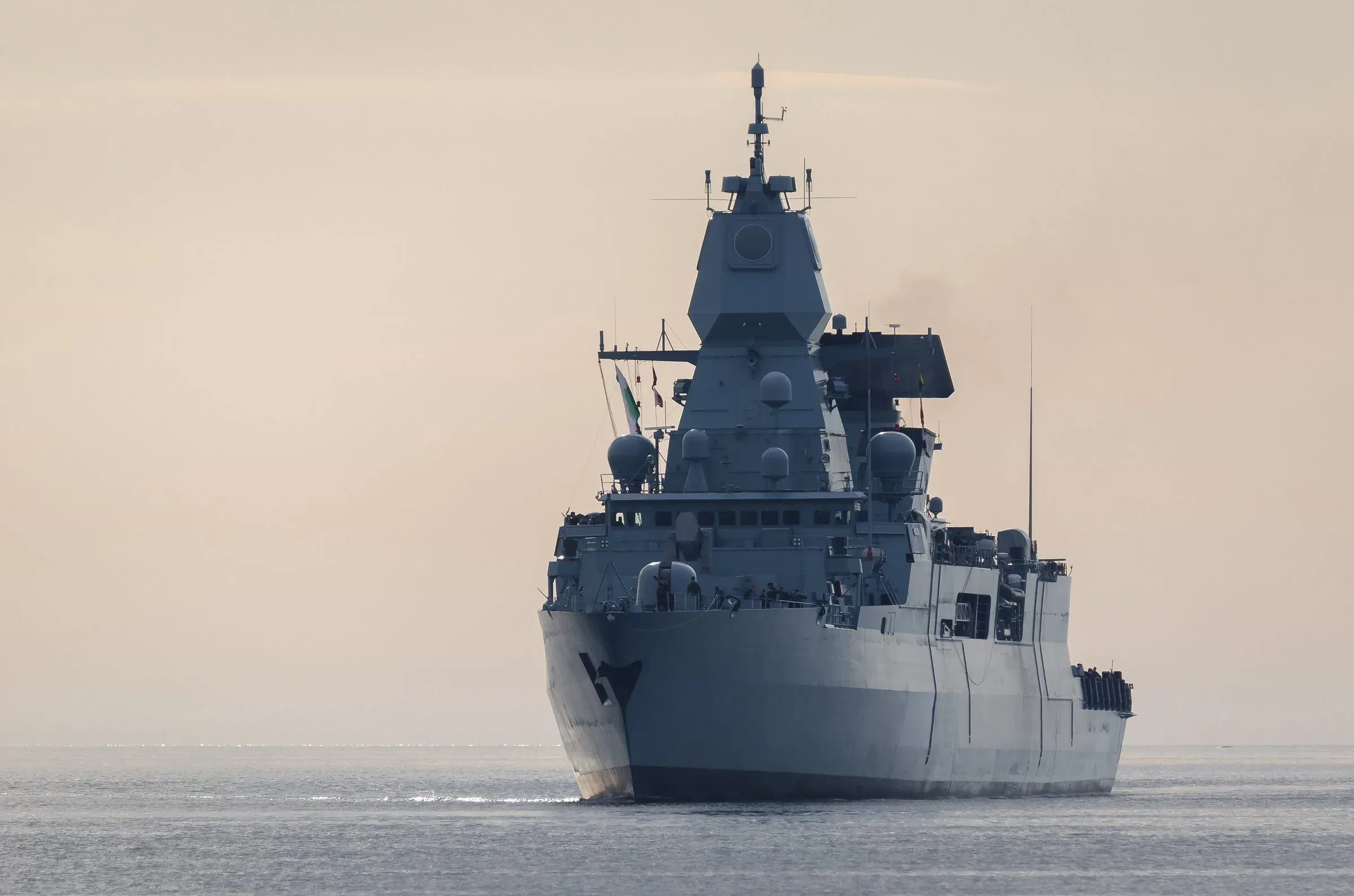 A military frigate at sea, viewed head-on.
